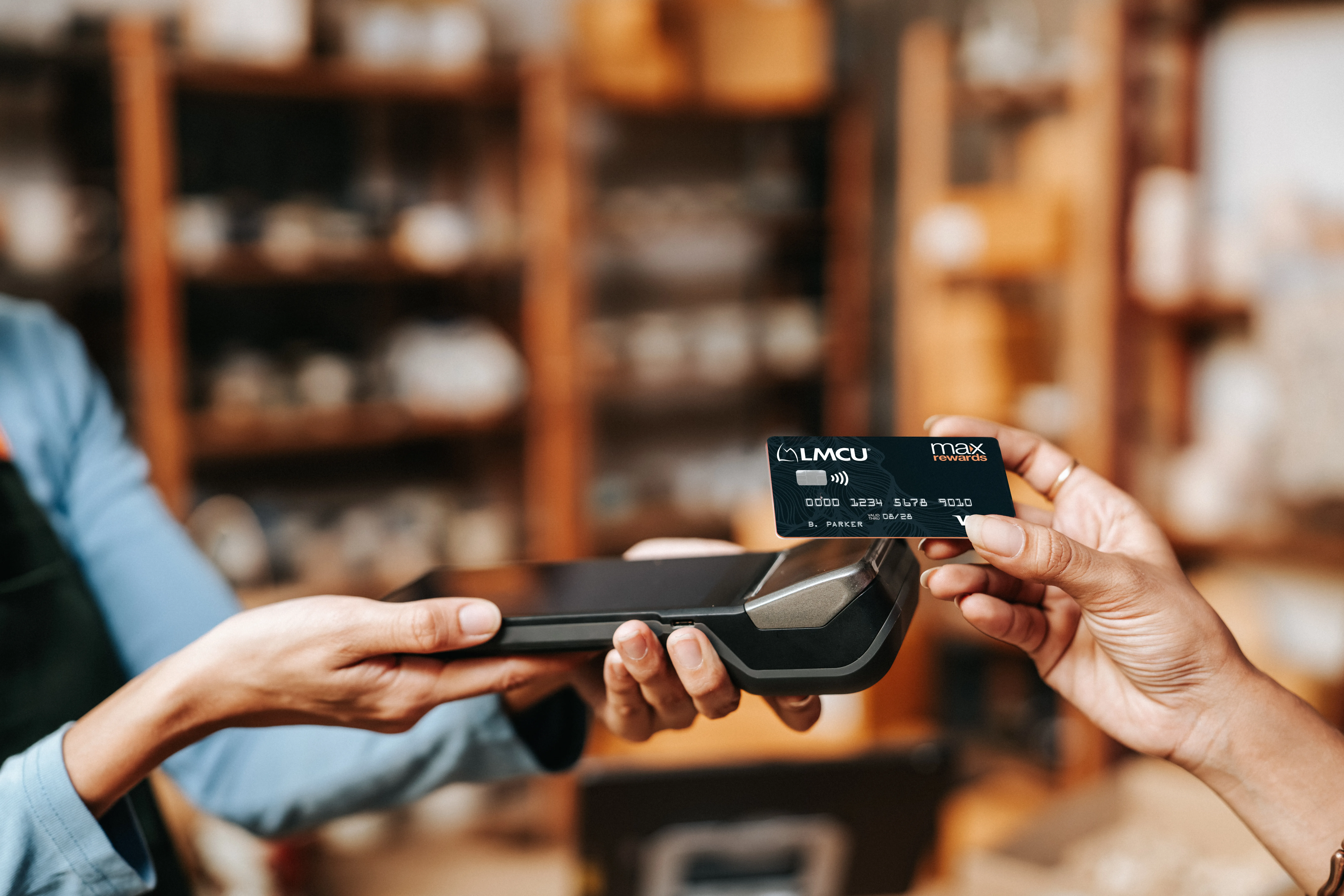 Customer taps a Max Rewards credit card on payment terminal at checkout. 