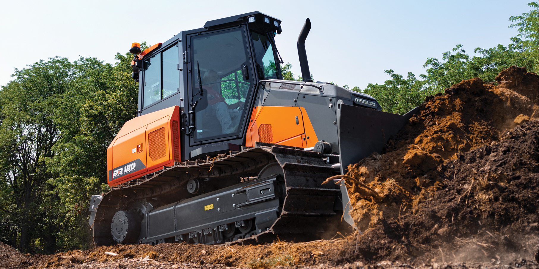 A DEVELON dozer pushing dirt on a job site.