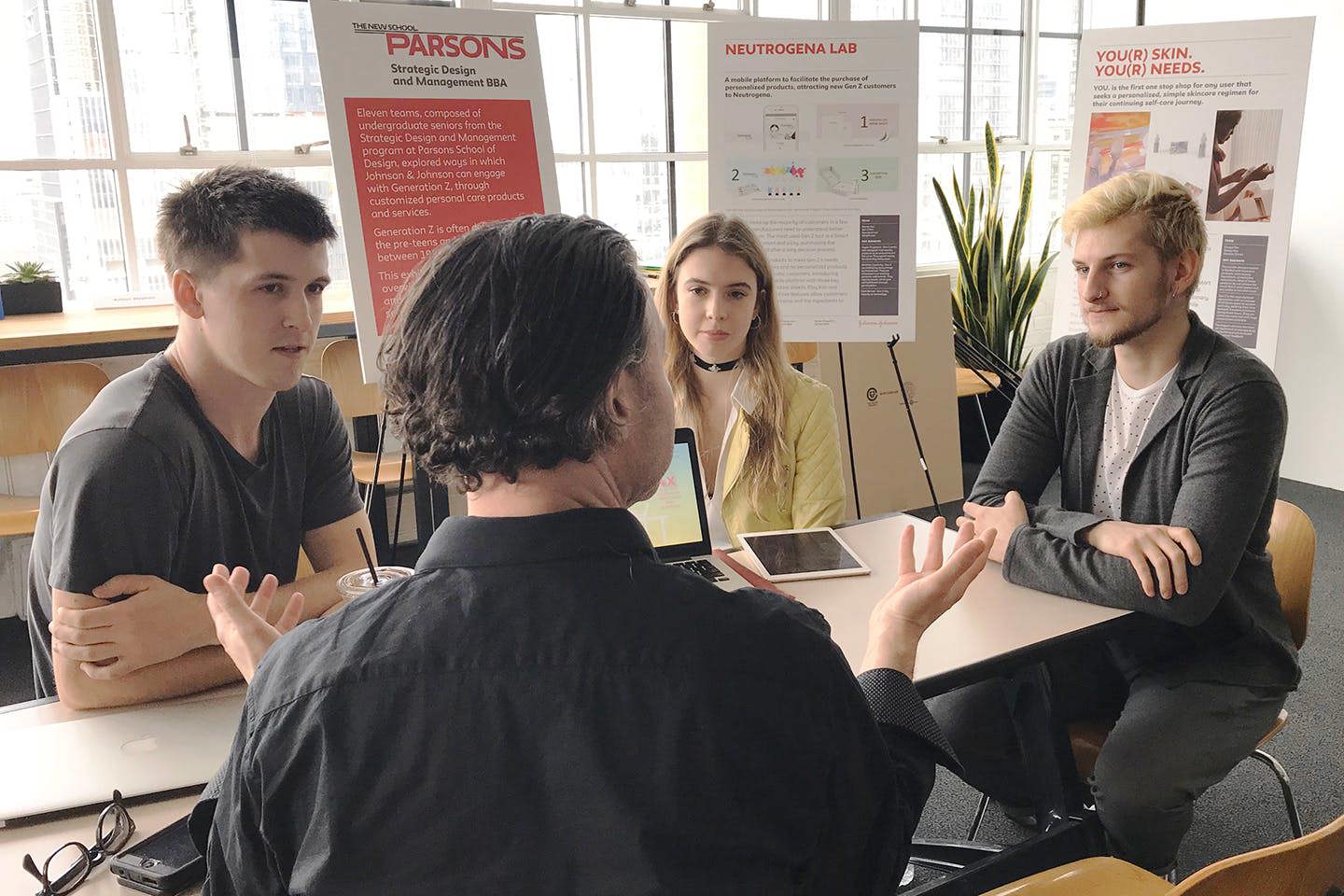 Parsons students engaged in a group discussion on a project for an external partner.