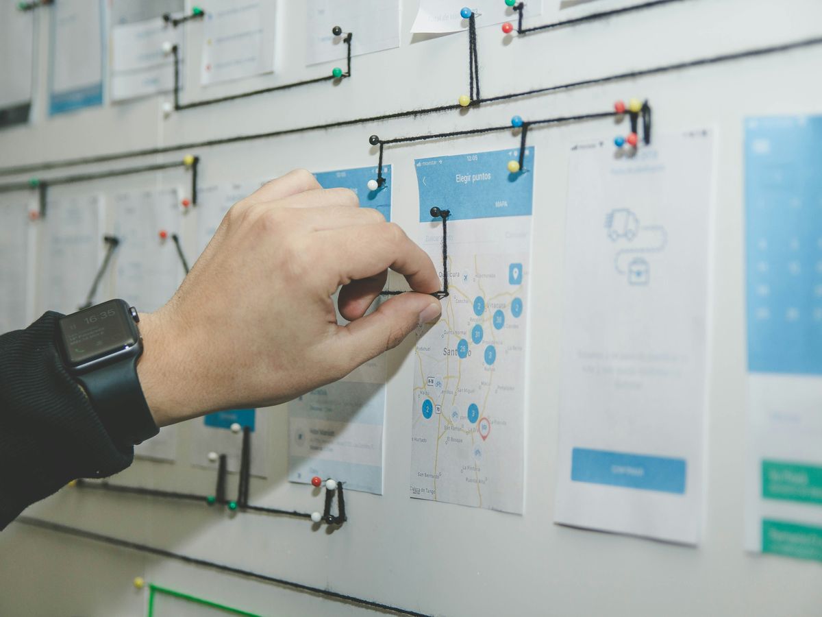 person working on blue and white paper on board