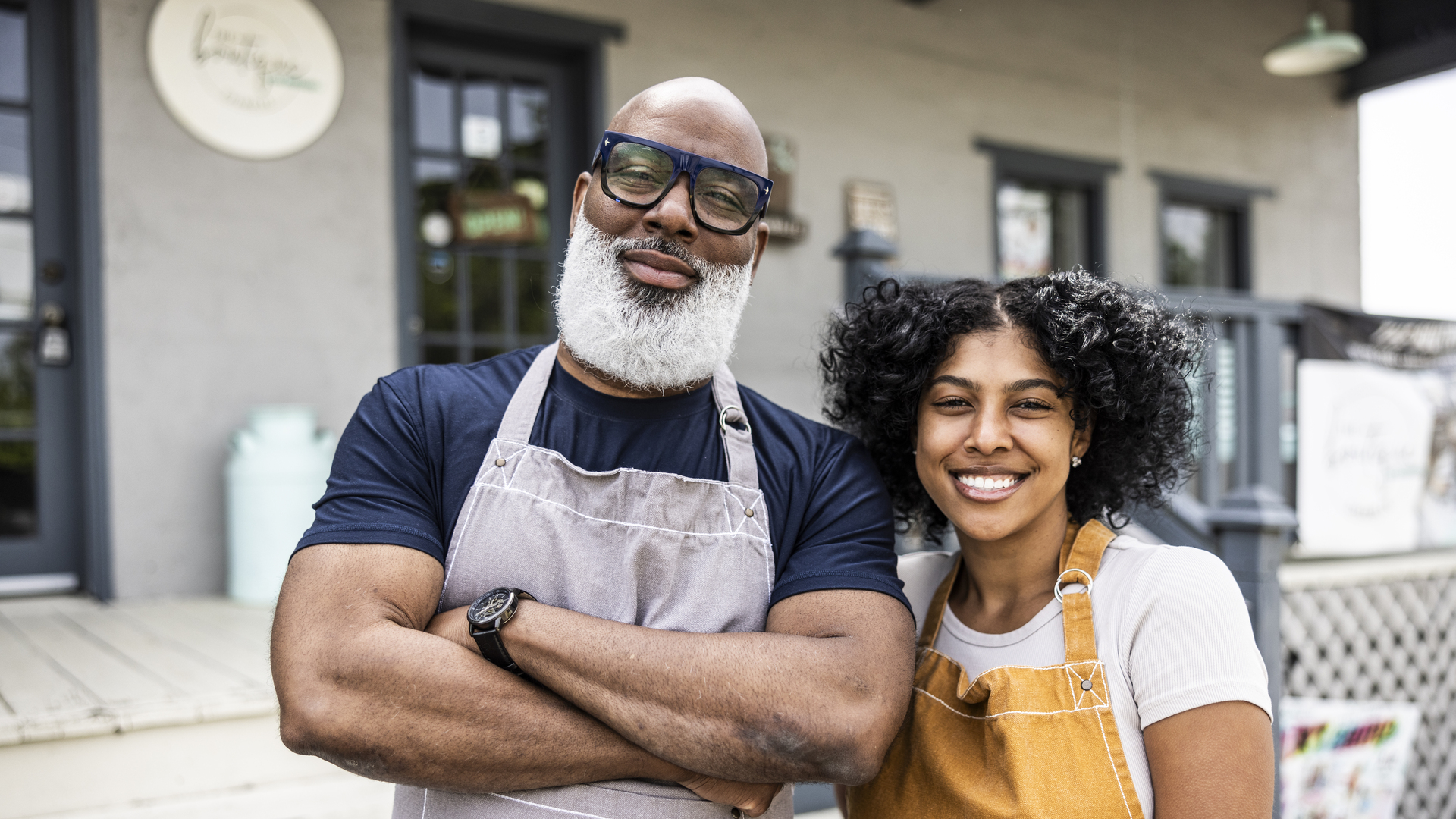 Portrait of father and daughter small business owners in front of family business
