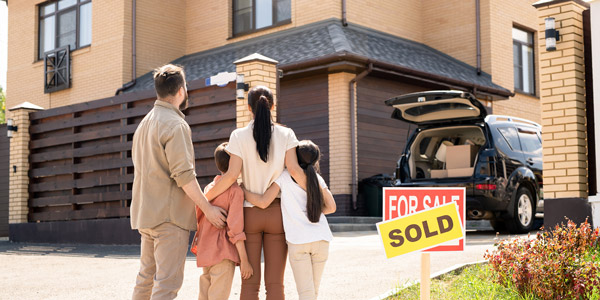 family standing outside looking at a home with a 