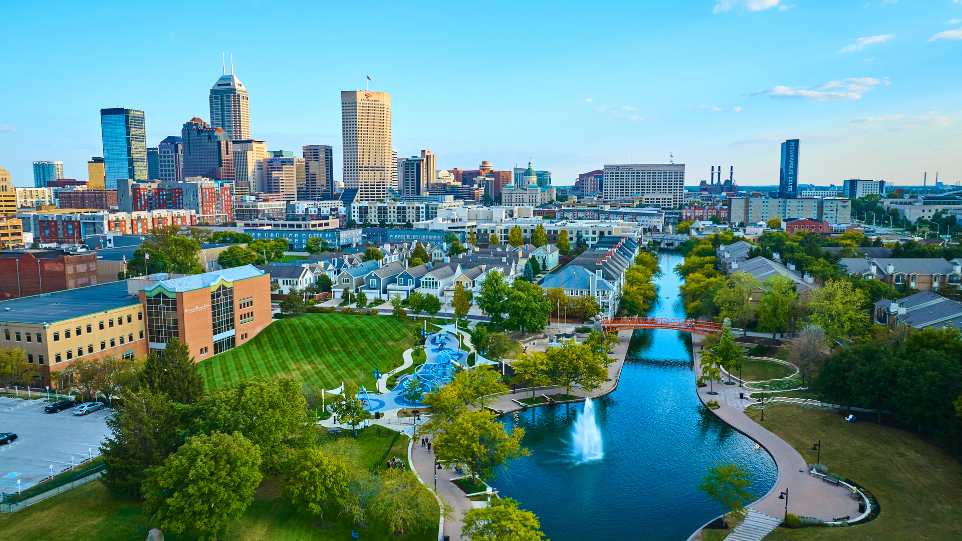 Aerial View of Urban Park with Orange Bridge and City Skyline