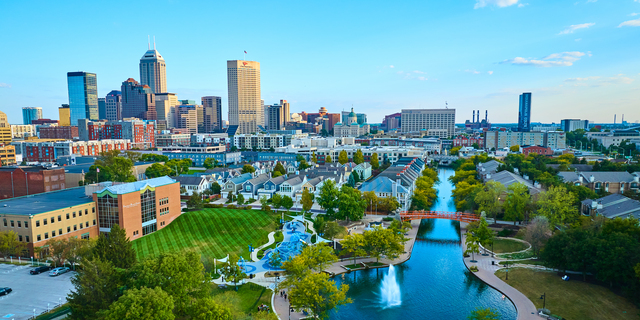 Aerial View of Urban Park with Orange Bridge and City Skyline