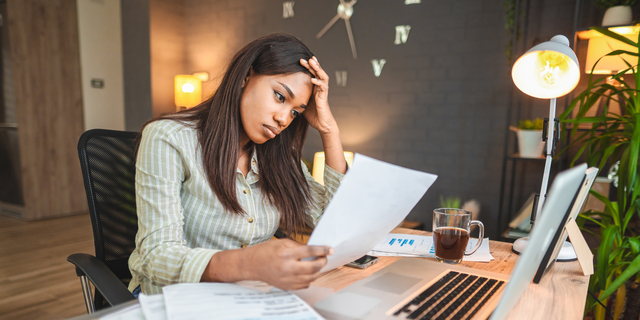 Worried young black women stressing over her financial bills