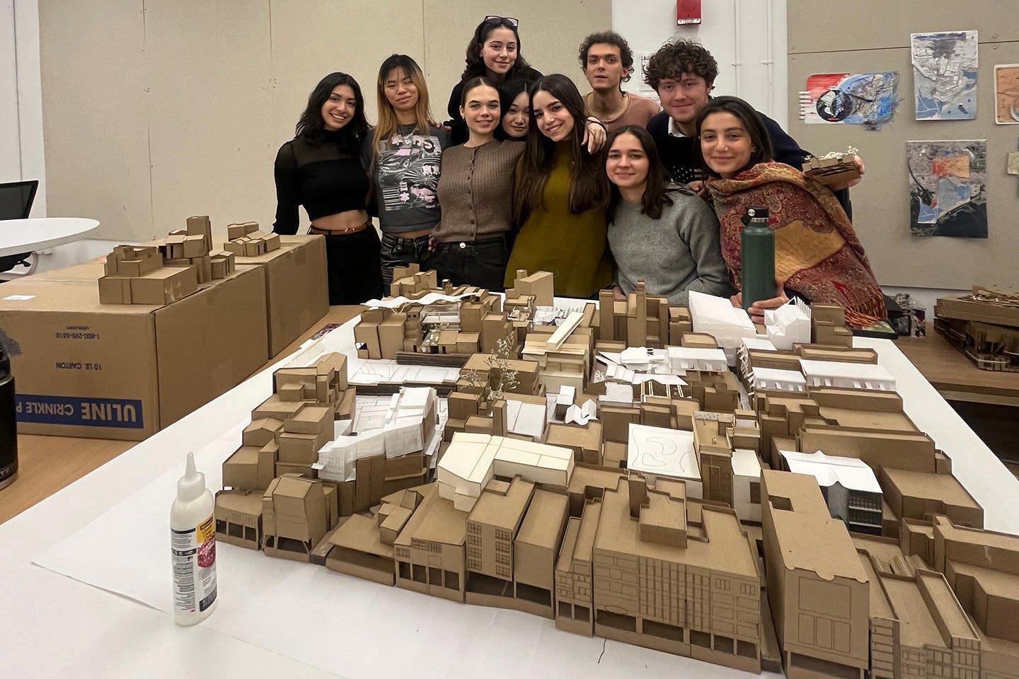 Ten students pose together in front of their 3D Blockology model of the Sweet Potato Hill neighborhood in Tainan, Taiwan, constructed from brown kraft paper.