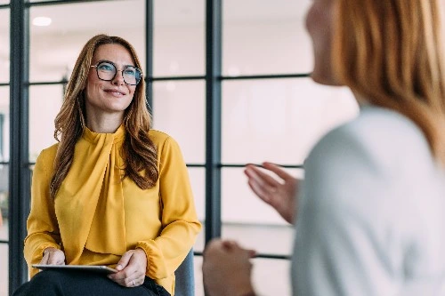 Image of two services industry professionals talking to each other and smiling