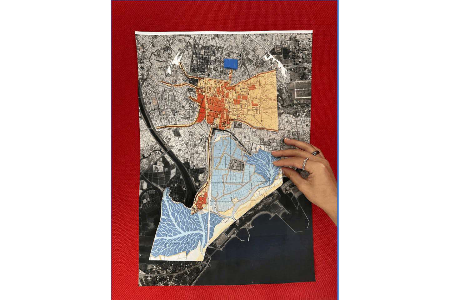 A hand holds a student-made layered map of the Tainan City shoreline, created by students Aviela Berk-Silverman, Katina Chang, and Senna Kotlizky.