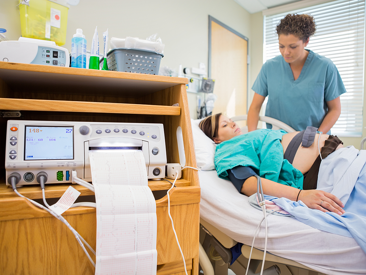 A physician navigates types of fetal monitoring with pregnant patient. 