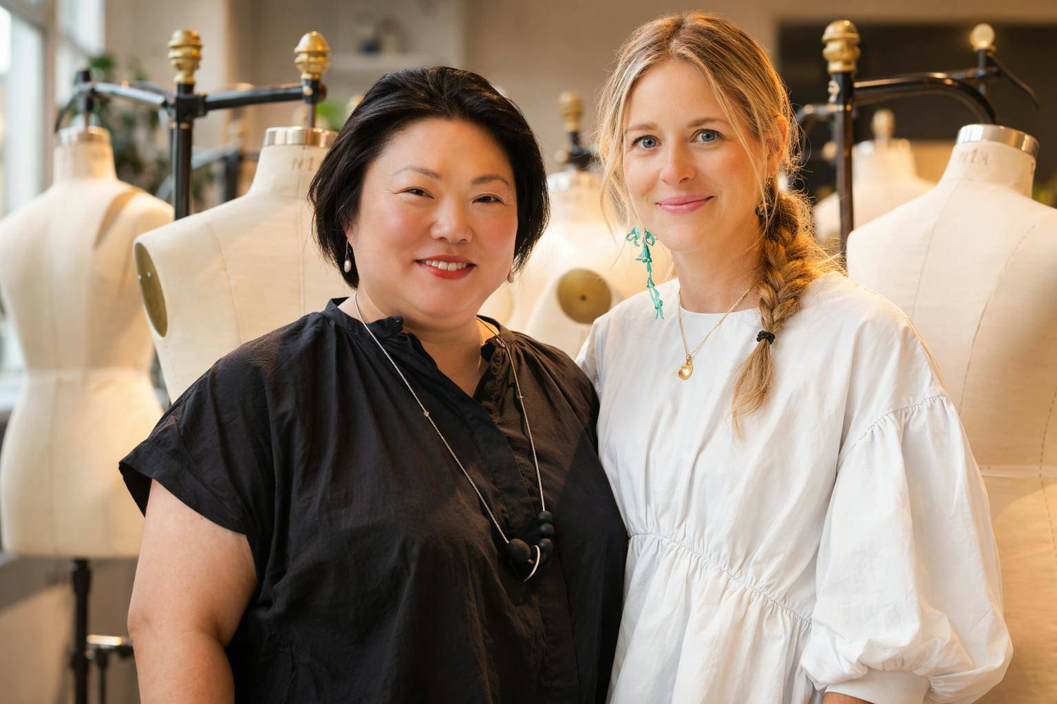Professors Leila Kelleher and Emily Huggard, stand in front of dress forms in a Parsons fashion program classroom.