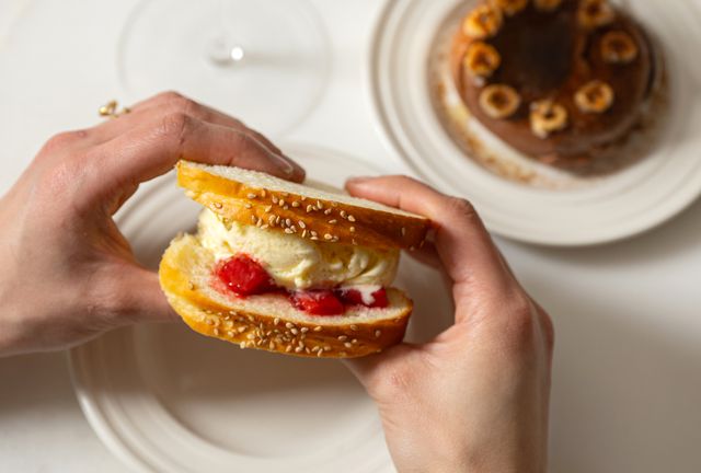 <p>Teddy Wolff</p> Chef Joshua Pinsky, Penny’s chef and co-owner, created the sandwich by replacing the traditional partially frozen cookie with a soft, sliced brioche and stuffing it with vanilla ice cream, passionfruit citron jam, and salted strawberries.