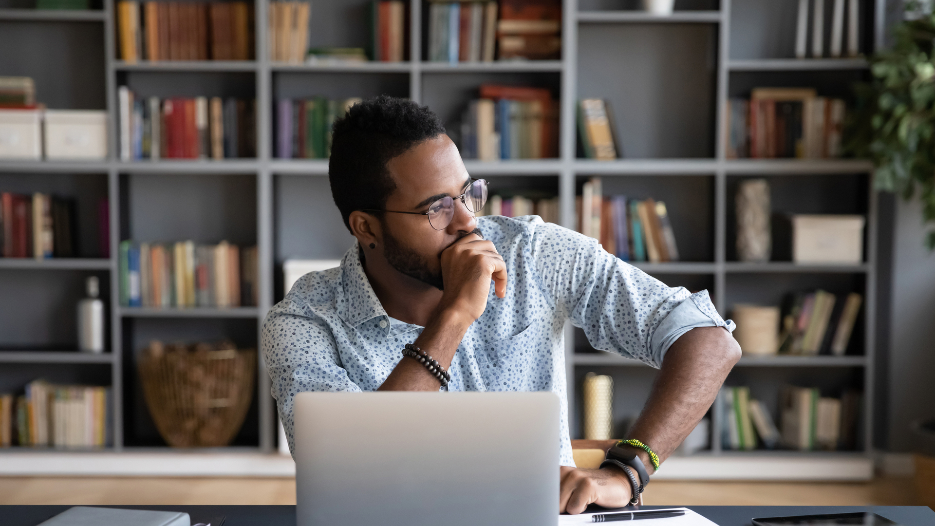 African businessman sitting at workplace thinking over problem solution