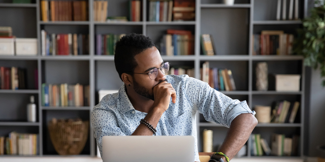 African businessman sitting at workplace thinking over problem solution