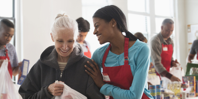 Volunteer handing out food at food drive