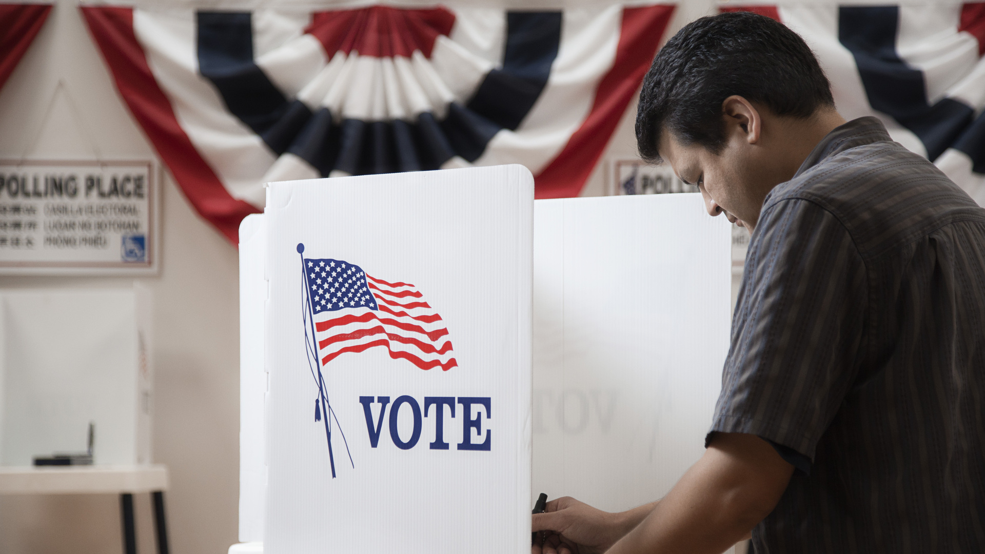 Mixed race voter voting in polling place