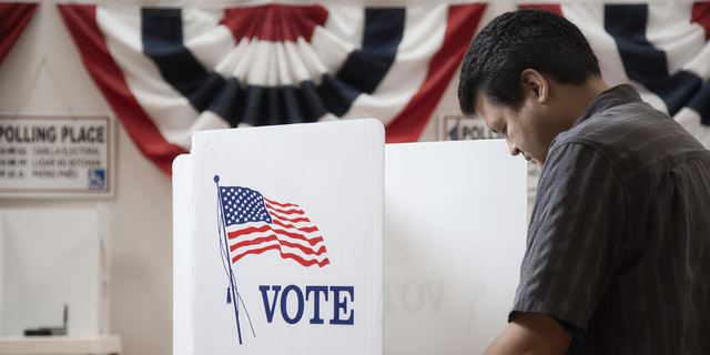 Mixed race voter voting in polling place