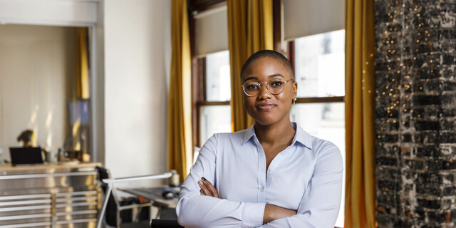 Confident female entrepreneur standing with arms crossed at office