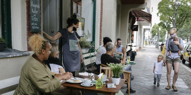 Owner welcoming customers at reopened restaurant