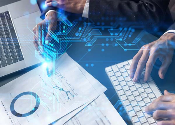 Hands working on a keyboard and pointing at data charts with a digital circuit overlay effect.