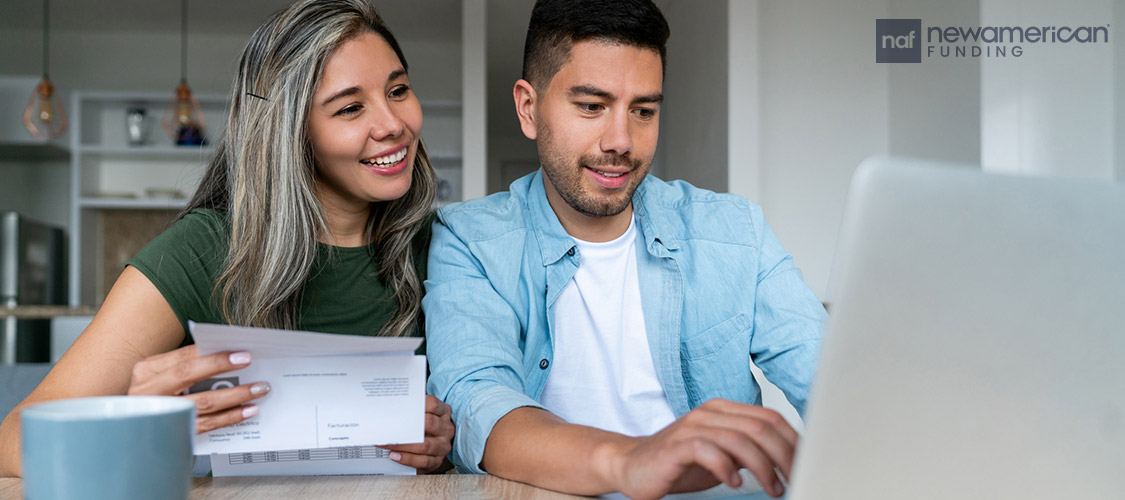 couple going over paperwork on laptop