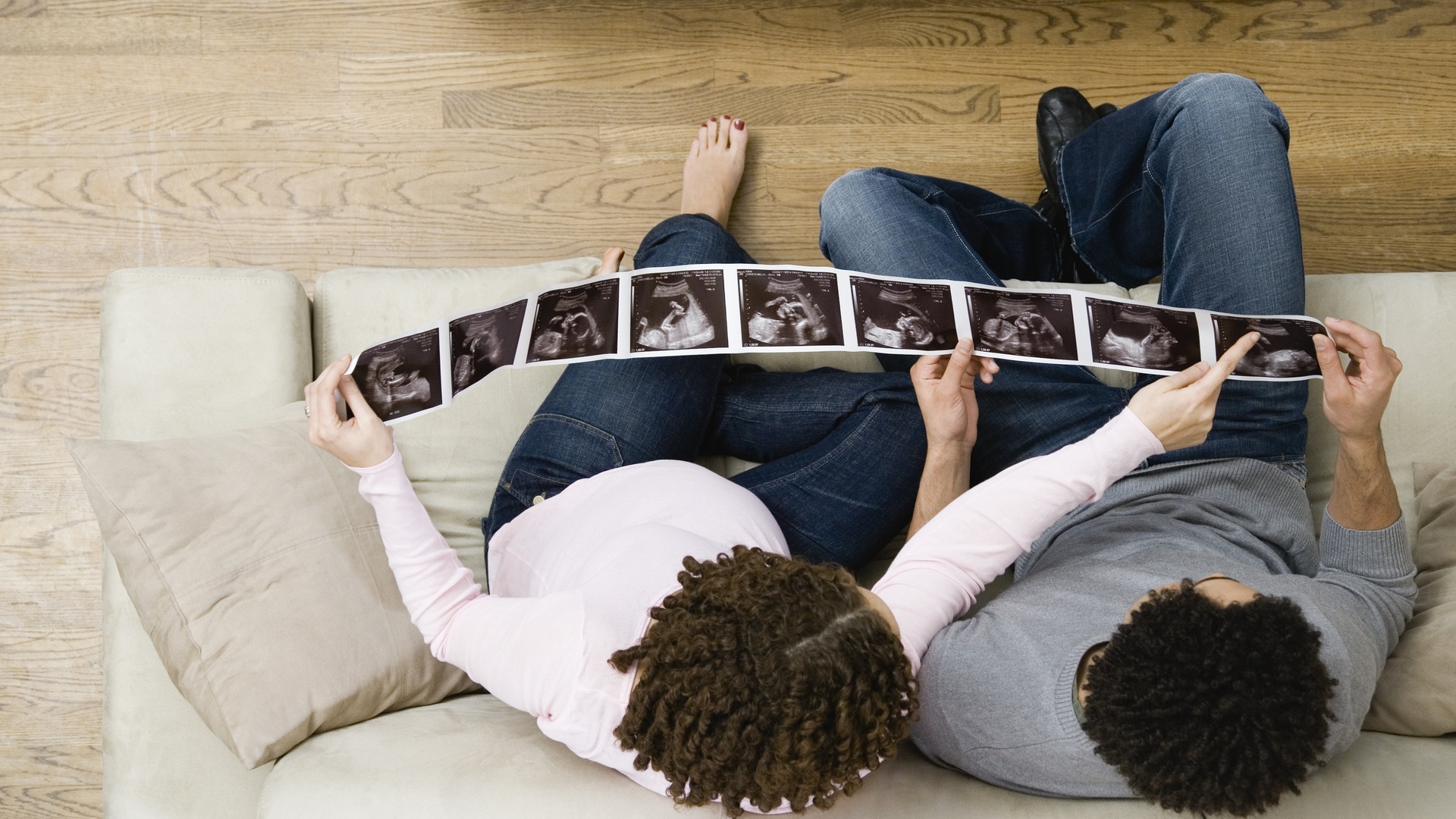 Pregnant African couple looking at ultrasound pictures