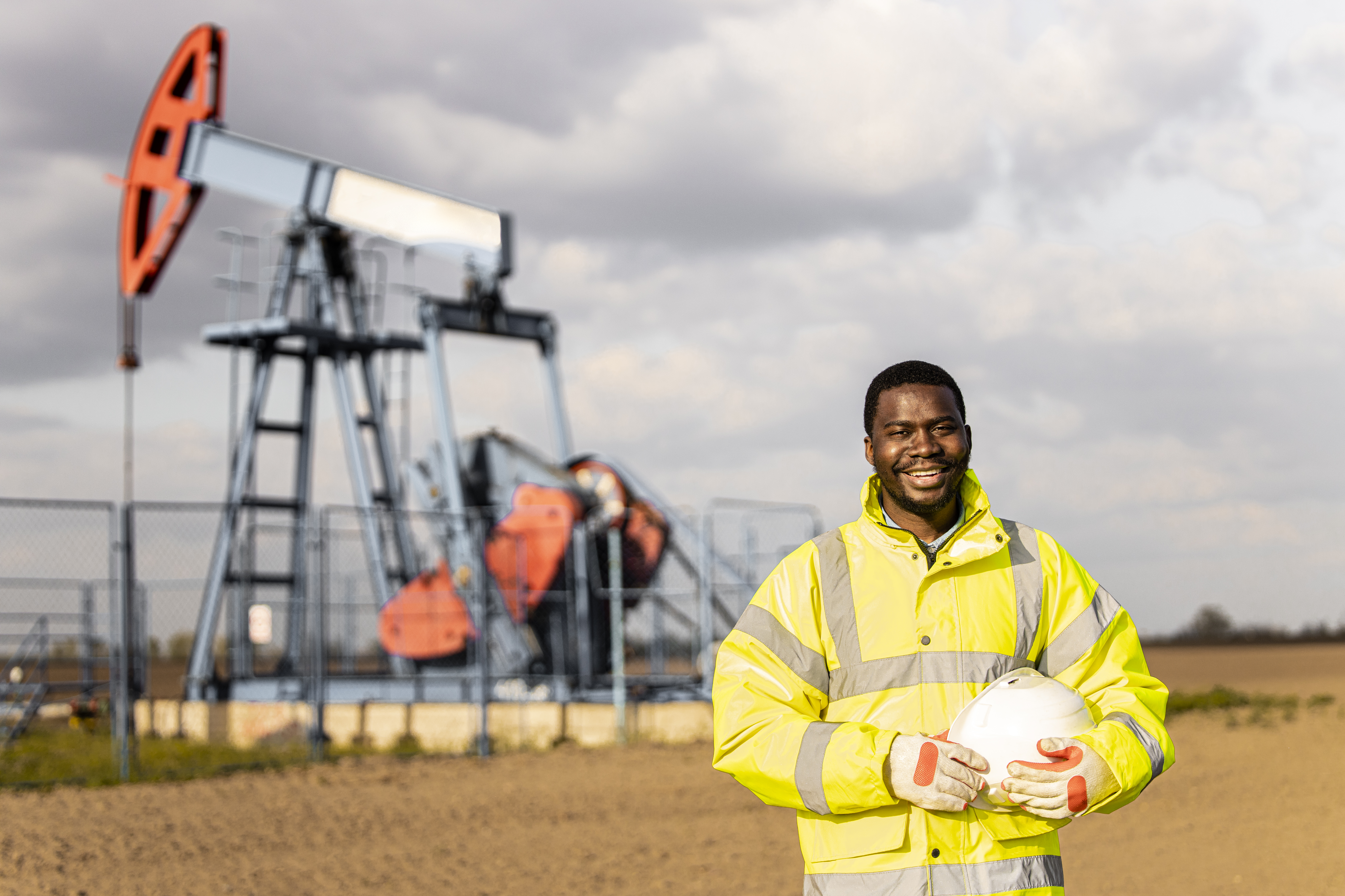 A field services worker stands near his oil field job.
