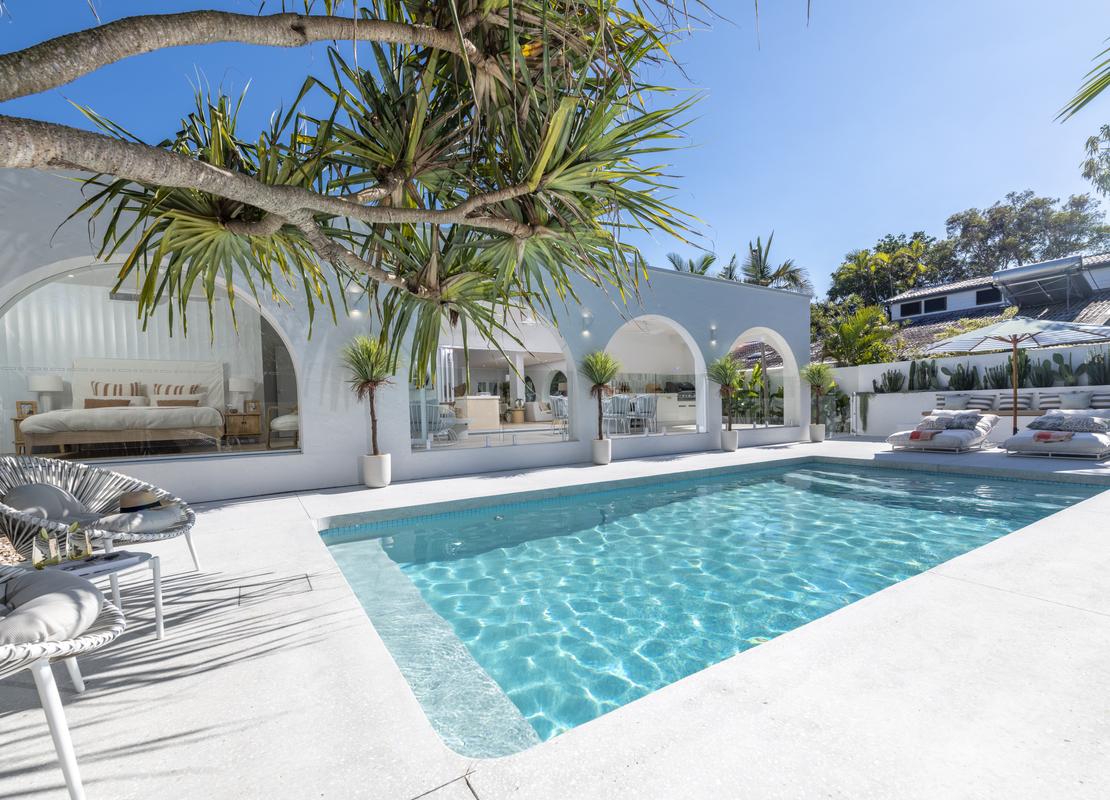 Shot of a pool facing a toward the alfresco of a house  