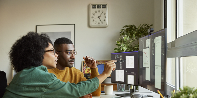 Multiracial colleagues discussing over computer