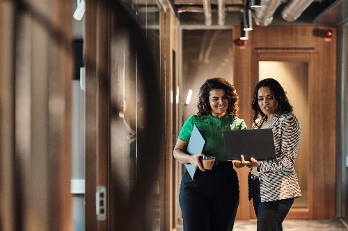 Image of two account executives in the services industry looking at a laptop screen