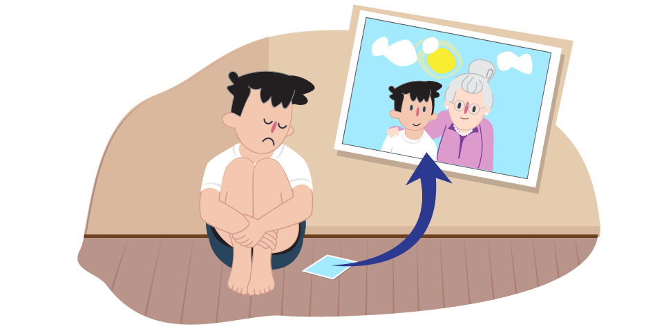 Illustration of a person sitting on the floor with knees drawn up. A framed photograph on the wall shows two people standing together outdoors, with an arrow pointing from the seated person toward the photo.
