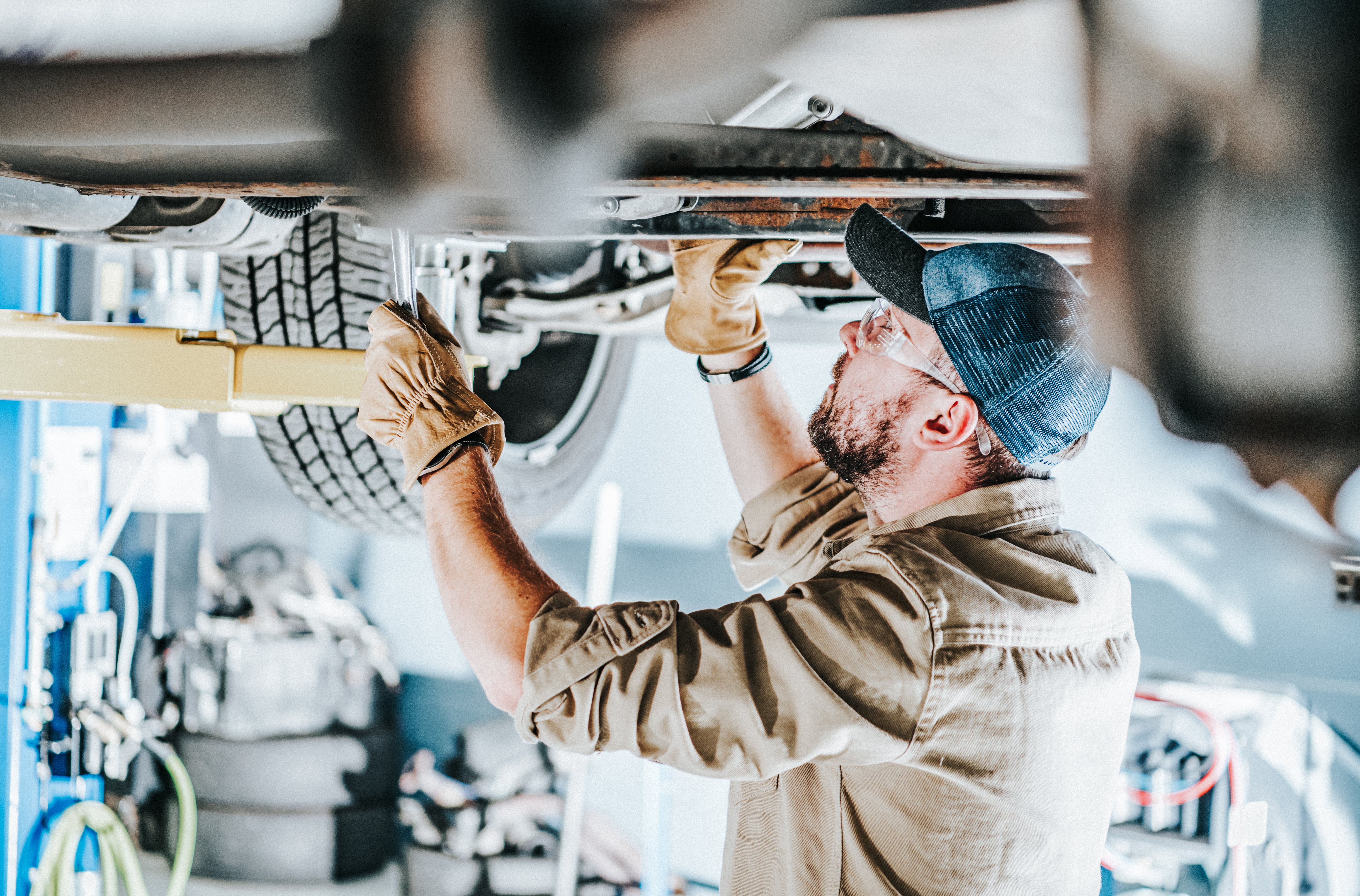  Automotive Industry Car Mechanic Performing a Vehicle Maintenance While on a Lift. 