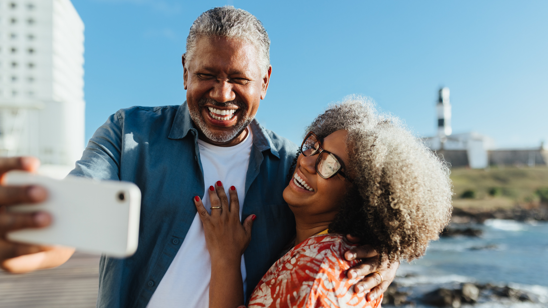 Golden Years: Cheerful senior couple taking a selfie on a sunny day by the sea