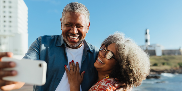 Golden Years: Cheerful senior couple taking a selfie on a sunny day by the sea