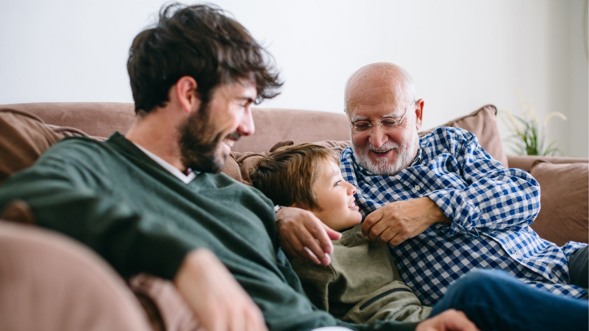 Dad receiving a wrapped Father’s Day gift from a child while sharing a meal together.
