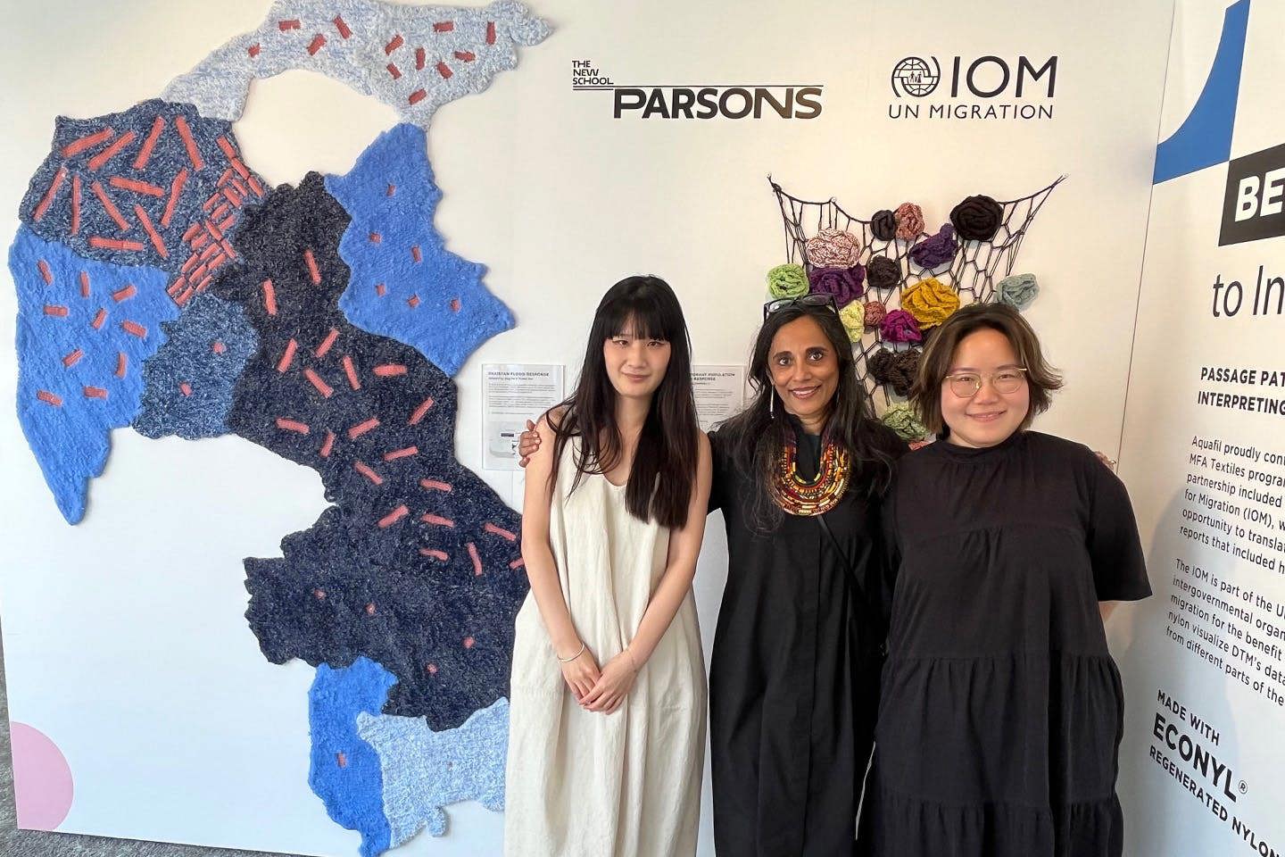 Preeti Gopinath poses with students Yichen Pan and Jing Pei in front of their west-faced weaving project, displayed at NeoCon.