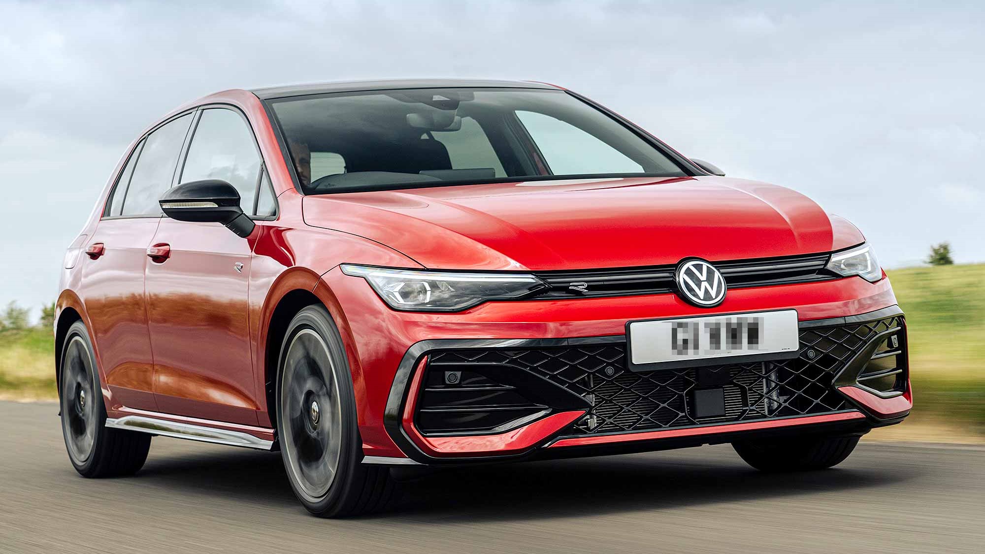 A red Volkswagen Golf driving on a road