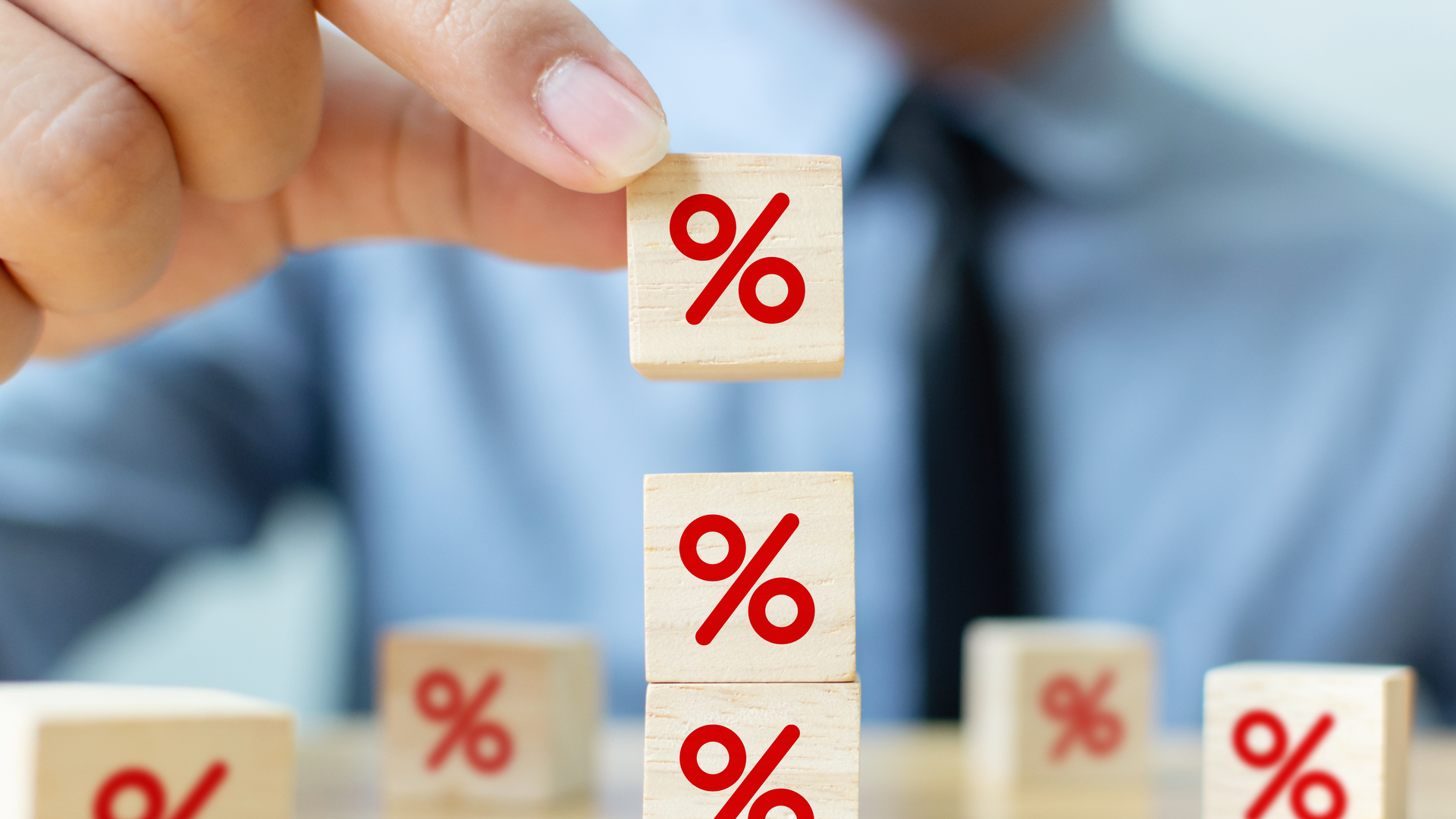 Interest rate financial and mortgage rates concept. Hand putting wood cube block increasing on top with icon percentage symbol upward direction