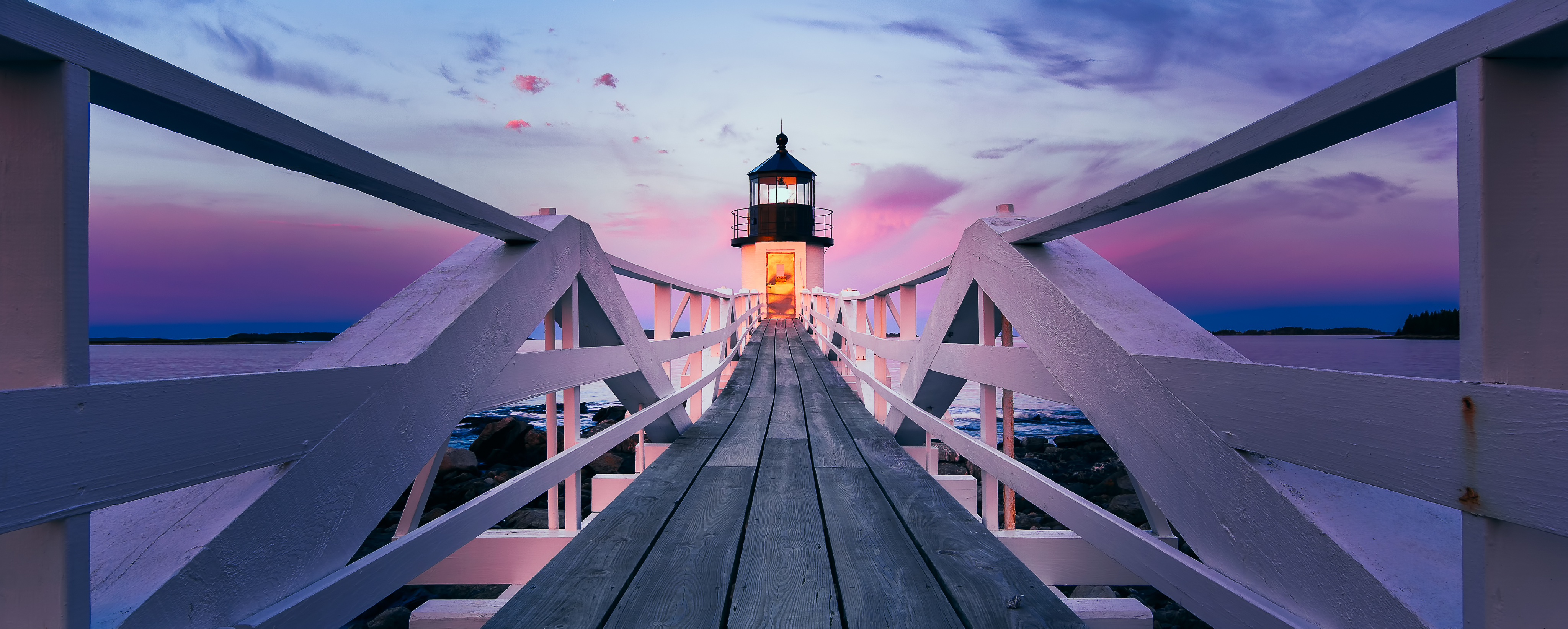 lighthouse at the end of a boardwalk