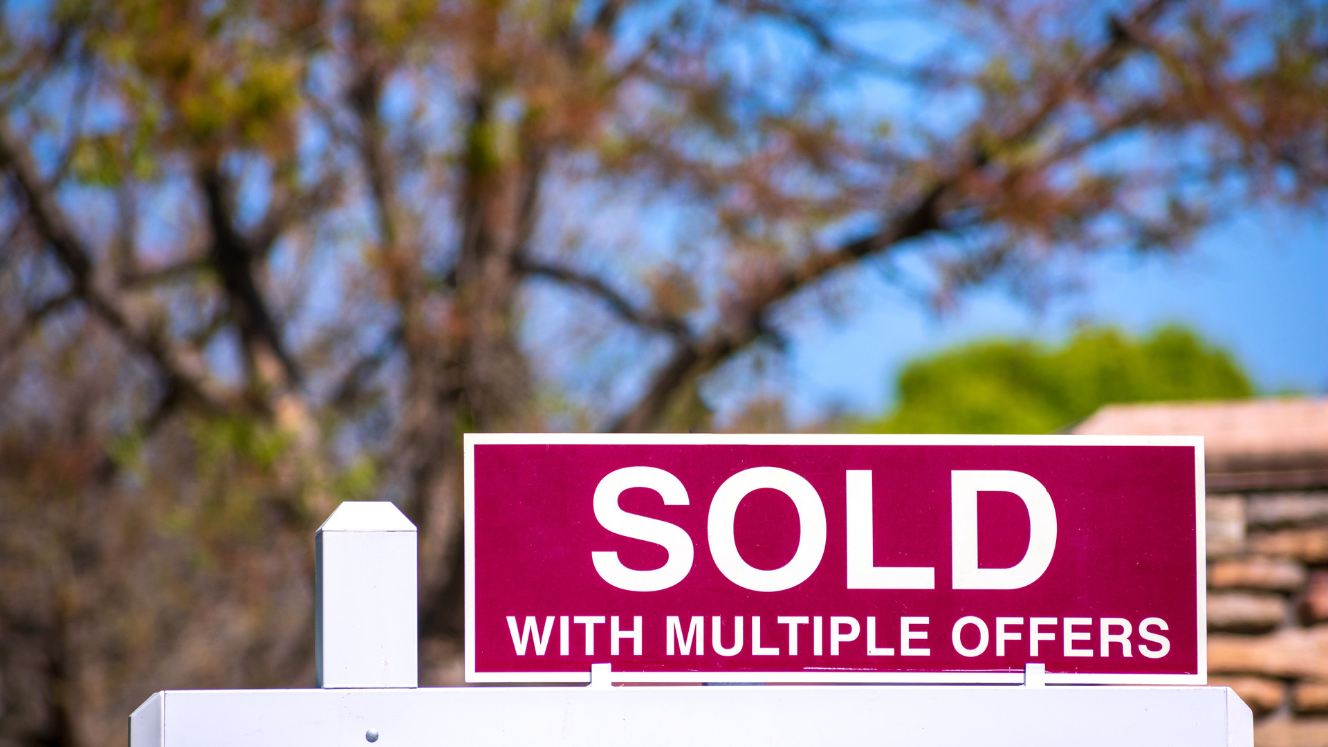SOLD With Multiple Offers real estate sign near purchased house.