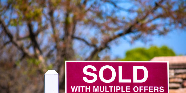SOLD With Multiple Offers real estate sign near purchased house.