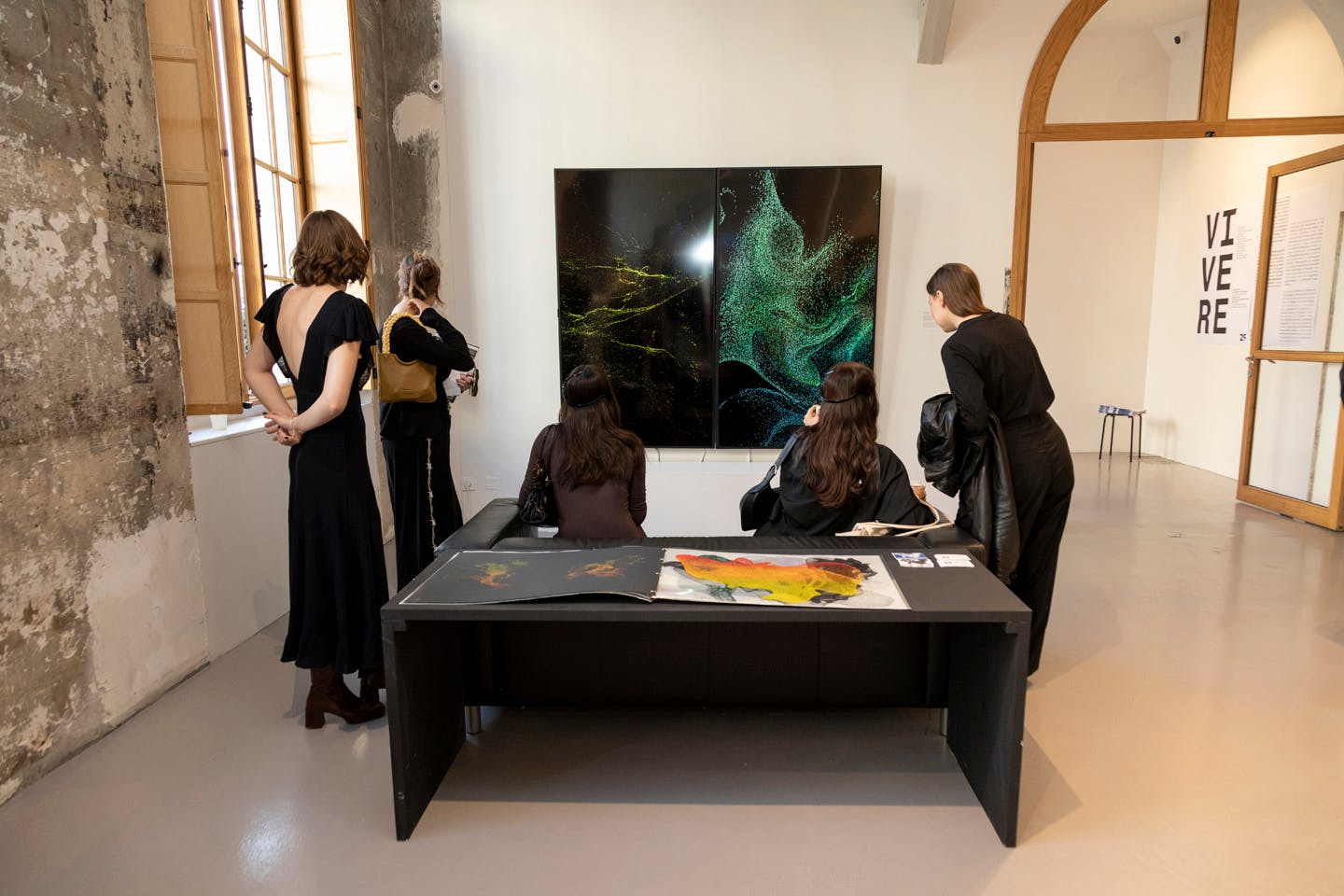Visitors viewing digital artwork with swirling light patterns on screens