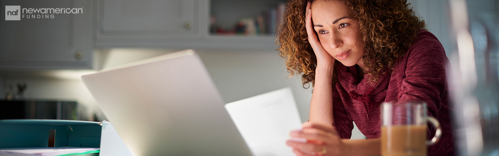 a woman looks at paperwork with a look of worry on her face