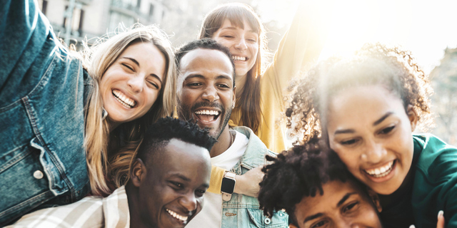 Happy multiracial friends having fun hanging out on city street - Group of young people laughing out loud together outside - Friendship concept with guys and girls enjoying weekend