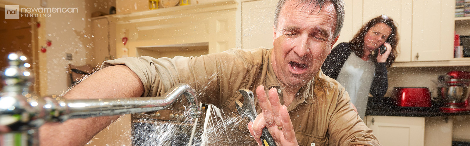 homeowner trying to fix broke kitchen pipes and water splashing everywhere