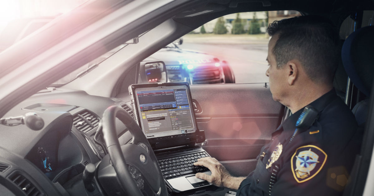 A police officer uses a rugged device in the field.