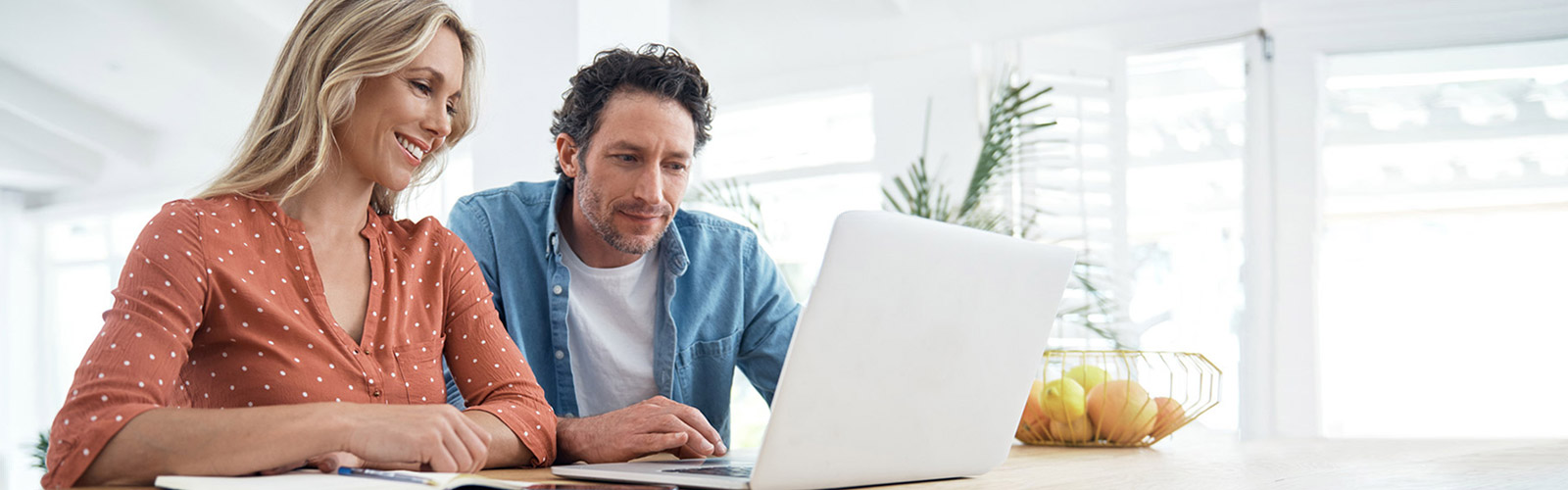 couple reviewing paperwork on laptop