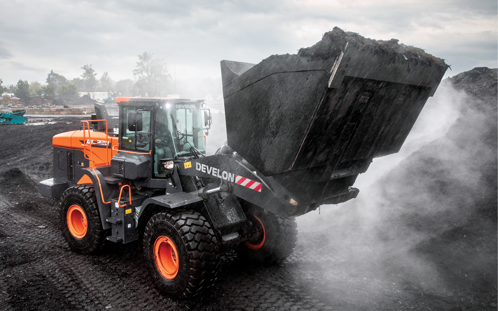 A DEVELON wheel loader operator lifts material using a high-capacity bucket.