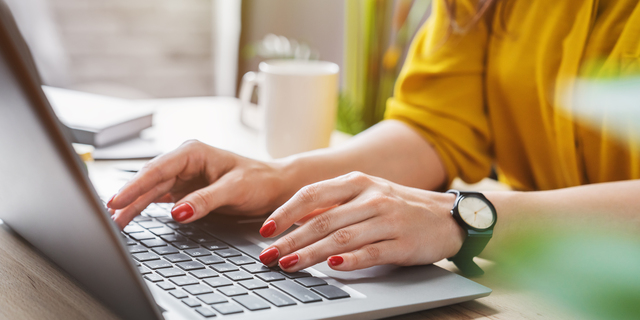 Cropped image of business woman hand working laptop computer in home office
