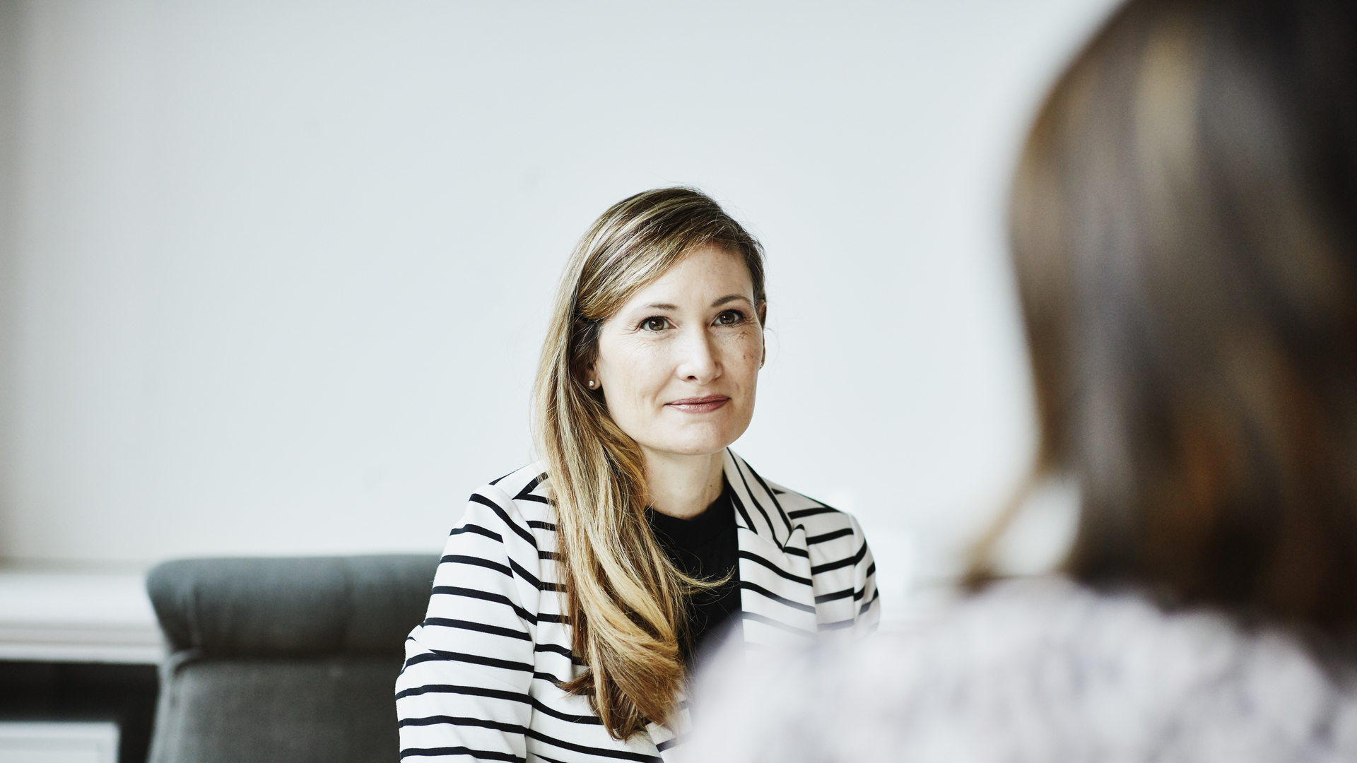 Female financial advisor in discussion with client during meeting in office