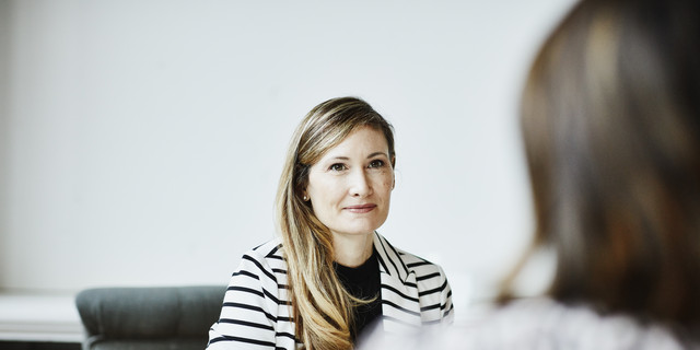 Female financial advisor in discussion with client during meeting in office